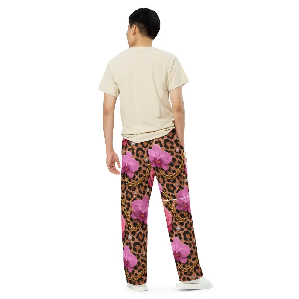 Man wearing Wild Glam Wide Leg Pants with leopard, chain, horse, and orchid print, back view