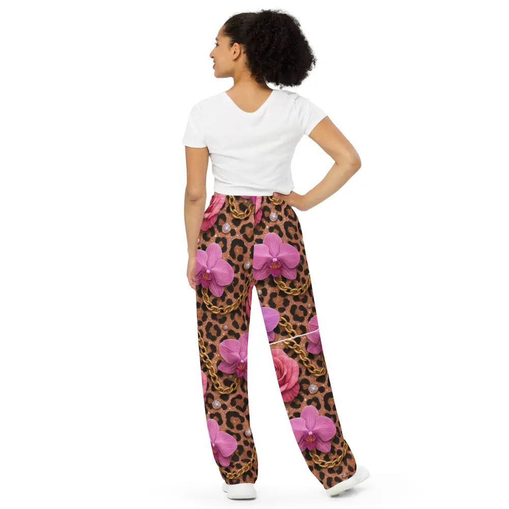 Woman wearing Wild Glam Wide Leg Pants with leopard, chains, horse, and orchid print, paired with white t-shirt.